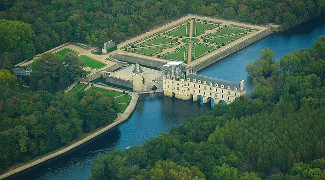 Aerial view of Château de Chenonceau spanning the Cher, with its two formal gardens
